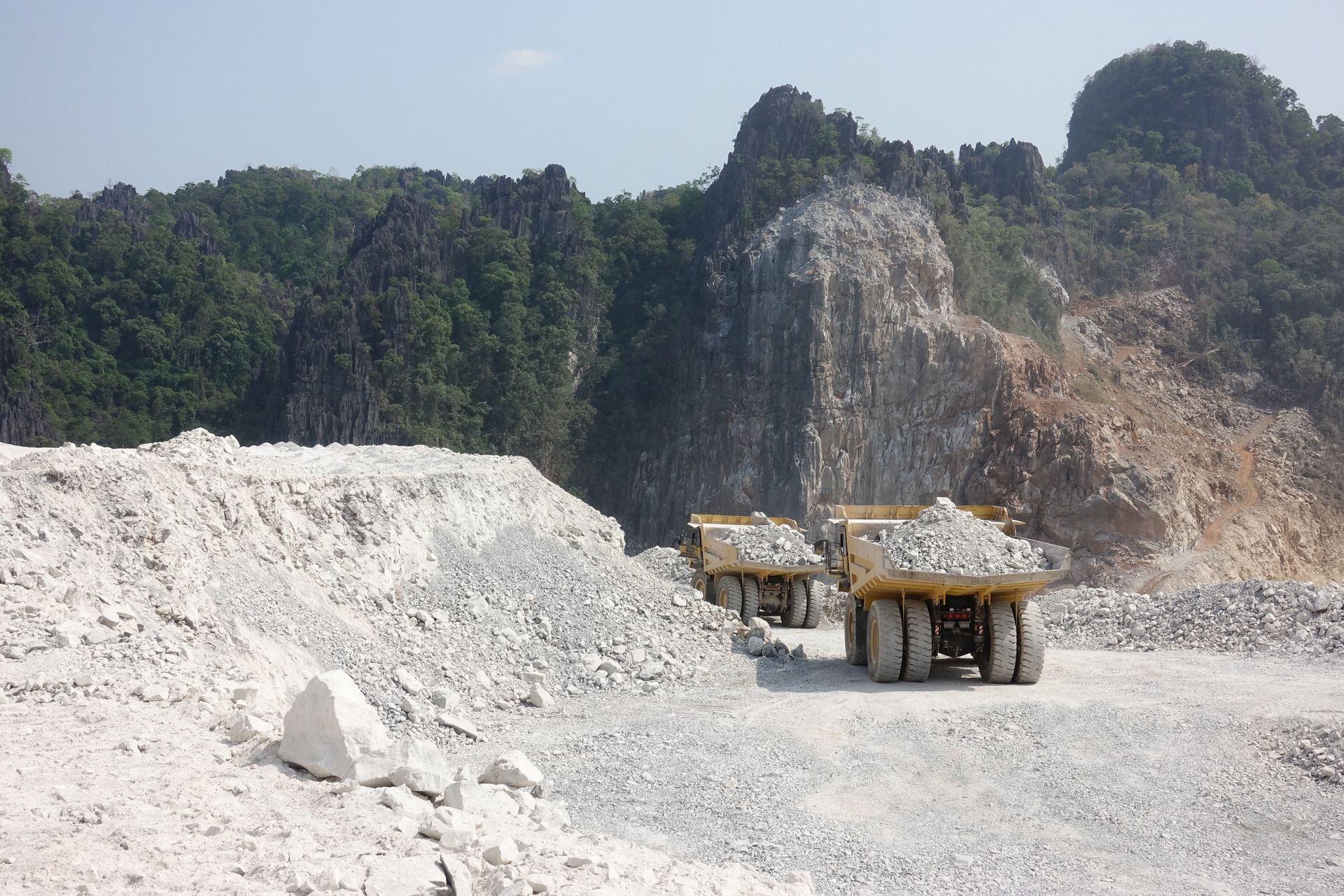 Dump trucks transport limestone to crusher in limestone mining.