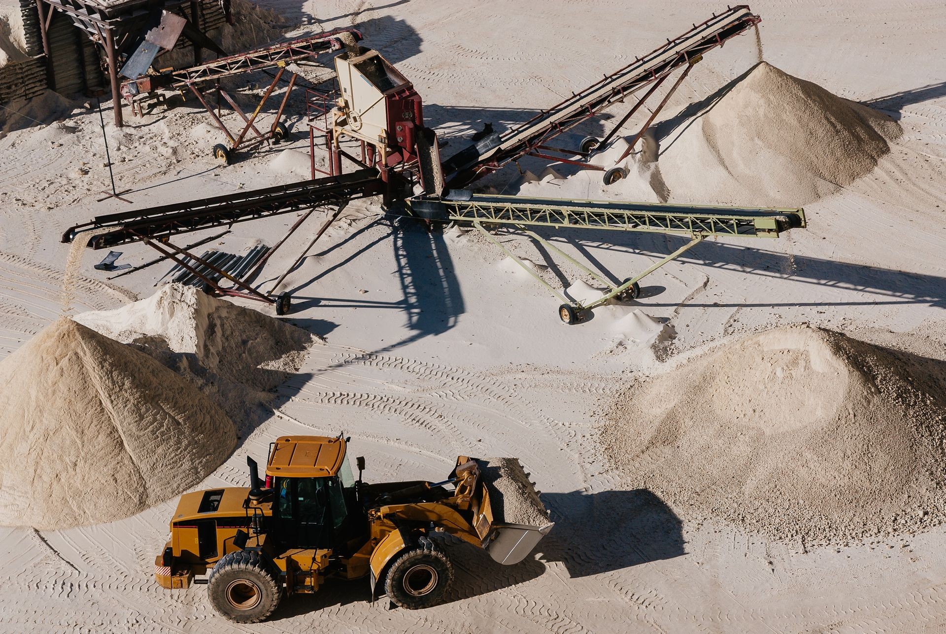 Excavartor taking out the white gravel selected by sorter machinery in surface gravel quarry